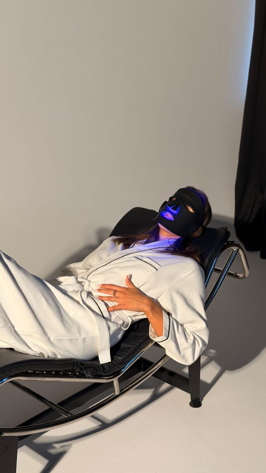 A woman lying on a lounge chair wearing the mask